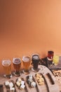 Snack platter with different cheeses with different kinds of cold beer on a bright orange or brown background.