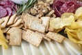 Snack platter featuring a selection of crackers, potato chips, cured salami, walnuts and thin slices of cheese Royalty Free Stock Photo