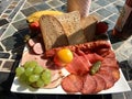 Snack platter with ham, sausages, bread, and grapes Royalty Free Stock Photo