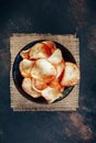 Snack of Potatoes chips served in black bowl
