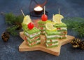 Snack, savoury spinach biscuit sandwices or canapes layered with cream cheese and salted salmon in Christmas and New Year style on Royalty Free Stock Photo