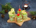 Snack, savoury spinach biscuit sandwices or canapes layered with cream cheese and salted salmon in Christmas style on a wooden Royalty Free Stock Photo