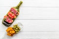 Snack set on wine bottles on white wooden desk from above copy space Royalty Free Stock Photo