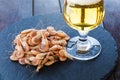 Snack from shrimps with a glass of beer on black stone plate and wooden table Royalty Free Stock Photo