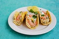 Snack, tacos with coleslaw salad, shrimp and corn tortilla sauce on a light clay plate on a turquoise concrete background