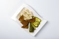 Snack to vodka. Plate with lard slices, rye bread, slices of pickle. The view from the top. On white background