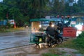 A snack vendor on a bike selling food in the rain