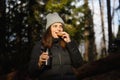 Snack on a walk in the woods. woman with thermos in nature