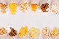 Snacks collection in craft paper cornets on white wooden board, top view, border. Royalty Free Stock Photo