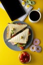 Snacks, fast food concept. Eatting at work place. Fresh club sandwich, vegetables, coffee, potato chips, sweet cookies. Tablet Royalty Free Stock Photo