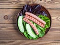 Snacks with lettuce and grilled nipples on a round plate close-up top view