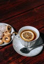 Snacks and sweets for tea in a small white saucer. Beautiful tea set. White ceramic Cup of tea with lemon on a wooden table Royalty Free Stock Photo