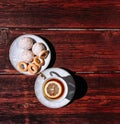 Snacks and sweets for tea in a small white saucer. Beautiful tea set. White ceramic Cup of tea with lemon on a wooden table Royalty Free Stock Photo