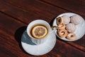 Snacks and sweets for tea in a small white saucer. Beautiful tea set. White ceramic Cup of tea with lemon on a wooden table Royalty Free Stock Photo