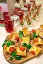 Snacks on a table, square slices of quiche with cherry tomatoes