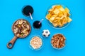 Snacks for TV watching. Chips, nuts, soda, rusks on blue background top view