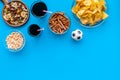 Snacks for TV watching. Chips, nuts, soda, rusks on blue background top view space for text