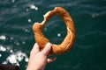 Snacky Turkish bagel sesame in his hand against a background seas Royalty Free Stock Photo