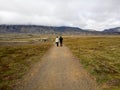 Unidentified tourists walking back from visiting Gatklettur Stone Arch,Iceland