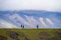 Unidentified tourists walking to see Gatklettur Stone Arch, Iceland