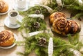 Snail chocolate muffins served with coffee on the background of a wreath of fir branches and cones. Rustic style. Royalty Free Stock Photo