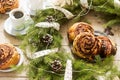 Snail chocolate muffins served with coffee on the background of a wreath of fir branches and cones. Rustic style Royalty Free Stock Photo