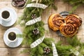 Snail chocolate muffins served with coffee on the background of a wreath of fir branches and cones. Rustic style Royalty Free Stock Photo