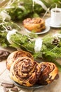 Snail chocolate muffins served with coffee on the background of a wreath of fir branches and cones. Rustic style. Royalty Free Stock Photo