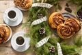 Snail chocolate muffins served with coffee on the background of a wreath of fir branches and cones. Rustic style Royalty Free Stock Photo