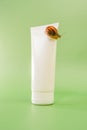 Snail cosmetic.Snails on a tube on a green background.Organic natural cosmetics with snail slime.Cosmetic tube with