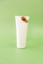 Snail cosmetic.Snails on a white tubeon a green background. natural cosmetics with snail slime.Cosmetic tube with snail