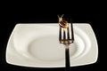 Snail on a fork against a white plate Royalty Free Stock Photo