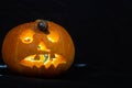 Snail on the ominous glow from inside an orange pumpkin