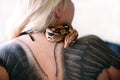 Snake on female shoulder and back, part woman body. Boa constrictor snake crawling per womanÃ¢â¬â¢s back, shoulder, tattoo.
