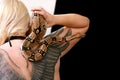 Snake on female shoulder and hand, part woman naked body. Boa constrictor snake crawling per woman hand and shoulder.