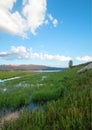 Snake River and grassy bank in the morning under cumulus clouds in Alpine Wyoming Royalty Free Stock Photo