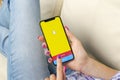 Snapchat application icon on Apple iPhone X smartphone screen close-up in woman hands. Snapchat app icon. Social media icon. Socia Royalty Free Stock Photo