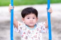 Snapshot of an Asian little child boy holding a blue swing. Children are playing on the playground in the evening. In the summer Royalty Free Stock Photo