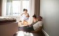 Snapshot of diverse family playing with happy children on floor at home run around in motion, authentic family life