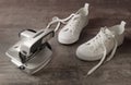Snapshot of the nineties. An old camera and white children sneakers on a old textured wood background. Concept - memory of 90th