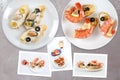 Snapshots of various sandwiches with seafood arranged on rustic wooden background with plates with food and seashells Royalty Free Stock Photo