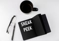 SNEAK PEEK written text in small black notebook with coffee , pen and glasess on white background. Black-white style