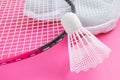 Sneakers, badminton rackets and shuttlecock on a bright pink background. Royalty Free Stock Photo