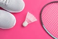 Sneakers, badminton rackets and shuttlecock on a bright pink background. Royalty Free Stock Photo