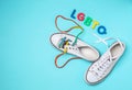 Sneakers with colorful shoelaces and abbreviation LGBTQ on color background