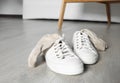 Sneakers with dirty socks on white wooden floor indoors Royalty Free Stock Photo