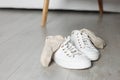 Sneakers with dirty socks on white wooden floor indoors Royalty Free Stock Photo