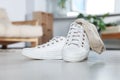 Sneakers with dirty socks on white wooden floor indoors Royalty Free Stock Photo