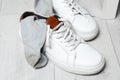 Sneakers with dirty socks on white wooden floor indoors Royalty Free Stock Photo