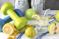 Sneakers, dumbbell, glass of water with lemon, measuring tape, jump rope, ball, lime, green Apple, on a gray